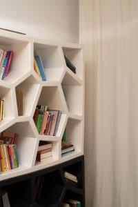 a white book shelf filled with books in a room at Set of Flats Vol 1 2 3 in Tríkala