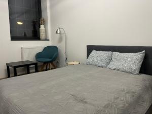 綠山城的住宿－Loft Stara Tkalnia，一间卧室配有一张床和一张蓝色椅子