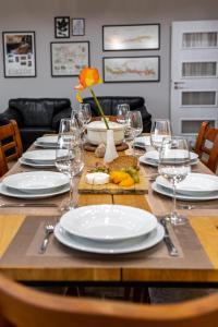 a table with plates and wine glasses on it at Villa Oreh Kravenik - Вила Орех Кръвеник in Kravenik