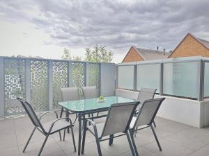 eine Terrasse mit einem Glastisch und Stühlen auf dem Balkon in der Unterkunft Richmond New 1br1ba Free Park Outdoor Bbq in Melbourne