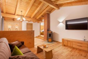 a living room with a couch and a tv at PANORAMA Allgäu Spa Resort in Seeg