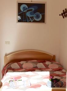 a bed with a comforter and a picture on the wall at Tra Mare e Pineta in Viareggio