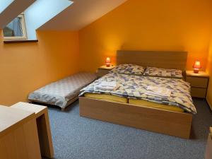 a bedroom with two beds and orange walls at Villa Aspen in Demanovska Dolina