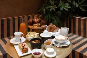 a table with cups and plates of food and coffee at Palazzo Petrvs in Orvieto