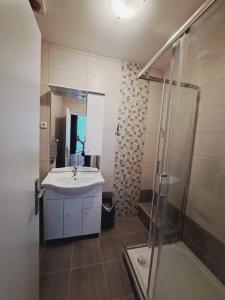 W łazience znajduje się umywalka i prysznic. w obiekcie Hotel Grand w mieście Tanvald