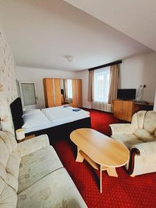 a hotel room with a bed and a table at Hotel Grand in Tanvald