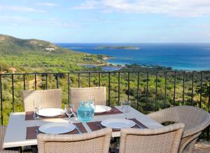 a table with chairs and a view of the ocean at Résidence Belvedere de Palombaggia in Porto-Vecchio