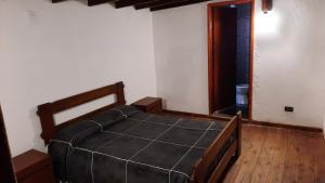 a bedroom with a bed with a black cover at LAS GRINGAS in Mar del Sur