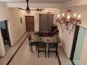 a dining room with a table and chairs and a chandelier at VarkalaEntireHomeKitchenAcRoomsHammocks in Varkala
