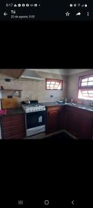 a kitchen with a stove and two windows at LAS GRINGAS in Mar del Sur