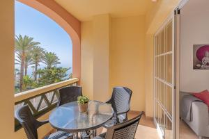 a dining room with a table and chairs and a balcony at Andaluz Apartments Toboso in Nerja