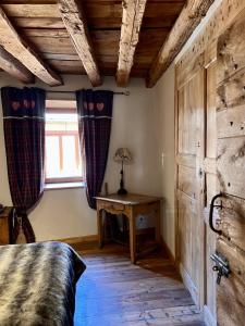 a bedroom with a bed and a table and a window at Appartement Esprit Chalet 71m² in Briançon