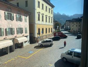 a white car parked on a street next to buildings at San15 in Predazzo