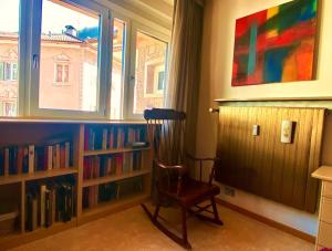 a room with a chair and a book shelf with books at San15 in Predazzo