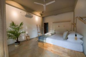 ein Schlafzimmer mit einem großen Bett und einer Topfpflanze in der Unterkunft Taboo in Hiriketiya
