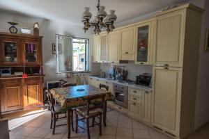 a kitchen with a table and a table and chairs at Casa Tiziana con Piscina privata e parcheggio riservato in Albenga
