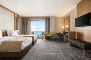 pokój hotelowy z 2 łóżkami i telewizorem z płaskim ekranem w obiekcie Ramada Resort by Wyndham Unye w mieście Unye