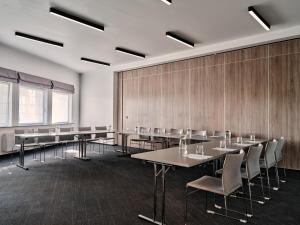 a conference room with tables and chairs and a wall at Hotel Edison in Przeźmierowo