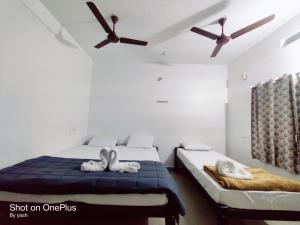 two beds in a room with two swans towels at Surya cafe and stay sea view in Gokarna