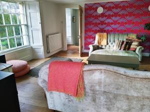 uma sala de estar com um sofá e uma parede vermelha em The Shire House em Lostwithiel