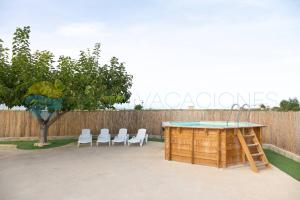 una mesa y sillas en un patio trasero con una valla en Illa - Casa rural aislada con piscina y cerca playa de la Marquesa -Deltavacaciones, en Deltebre