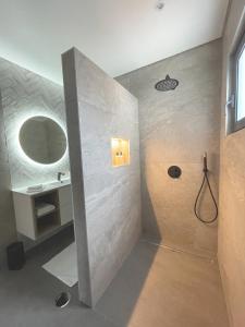 a bathroom with a shower with a sink and a mirror at Casa do Mundo Madeira in Gaula