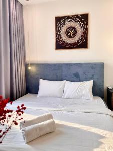 een slaapkamer met een bed met een blauw hoofdeinde bij Vinhomes Skylake Apartment 5 minutes to Kaengnam in Hanoi