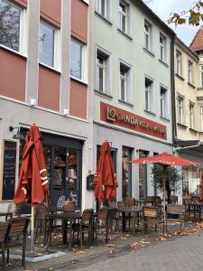 um grupo de mesas com guarda-chuvas em frente a um edifício em Charmante Altbauwohnung em Erlangen
