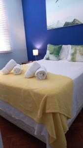 ein Schlafzimmer mit einem gelben Bett mit Handtüchern darauf in der Unterkunft Beach Block - View to Atlantic in Rio de Janeiro