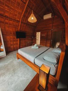 a bedroom with a bed in a wooden room at Bagus Ink Surf Camp in Uluwatu