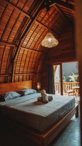 a bedroom with a bed with a teddy bear on it at Bagus Ink Surf Camp in Uluwatu