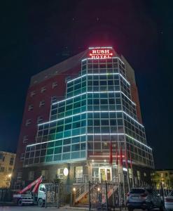 um edifício alto com um sinal em cima em "Rush Hotel" em Astana
