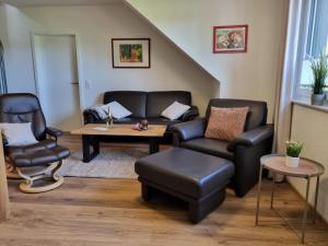 un soggiorno con divano, tavolo e sedie di Landhaus Westerloy a Westerstede