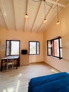 een kamer met een bed, een bureau en ramen bij Pavlos House in Symi