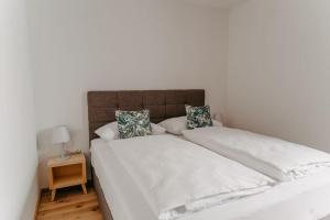 ein großes weißes Bett mit weißer Bettwäsche und Kissen in der Unterkunft Family *Relax Apartment* für 6 in den Weinbergen in Spielfeld