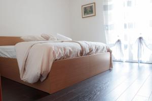 a bedroom with a bed with a wooden bed frame at Hotel Milano in Tione di Trento