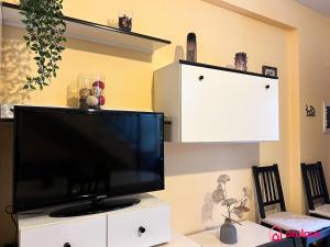 een flatscreen-tv zittend op een witte kast bij La Casona in Oropesa del Mar