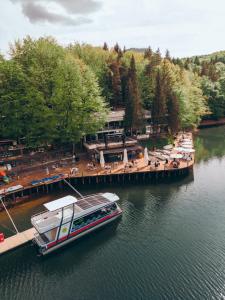 a boat is docked at a dock on a river at Adventure Lake Resort - Simared in Baia Mare