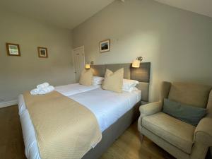a hotel room with a bed and a chair at Glenderamackin Cottage in Threlkeld