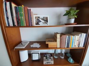 un estante de libros con libros y una planta en él en A casa di Ciccio da'mmonte, en Velletri