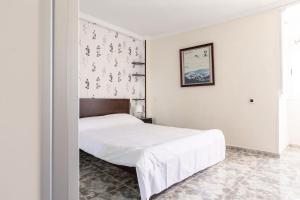 sypialnia z białym łóżkiem i obrazem na ścianie w obiekcie Atlantic Pearl w mieście Candelaria