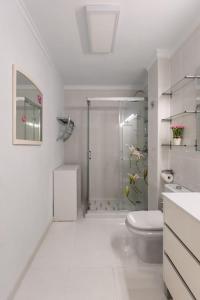 biała łazienka z prysznicem i toaletą w obiekcie Atlantic Pearl w mieście Candelaria