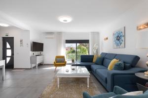 sala de estar con sofá azul y mesa en Villa Crown22, en Quarteira
