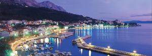a view of a harbor with boats in the water at night at Apartments Mia in Podgora