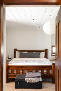 1 dormitorio con 1 cama grande de madera en una habitación en Old Cobbin Homestead (est. 1864), Snowy Mountains, en Moonbah