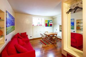 a living room with a red couch and a table at Sweet Home Colosseo in Rome