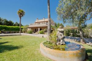 a house with a fountain in the yard at Villa Cifre in Alcudia
