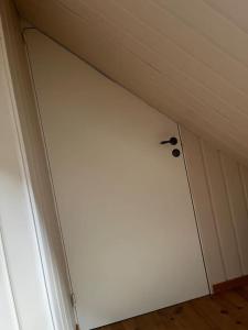 a white door in a room with a ceiling at Posthuset in Veblungsnes