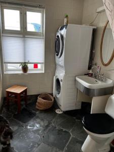 a bathroom with a toilet and a sink and a refrigerator at Posthuset in Veblungsnes