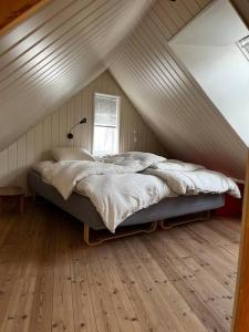 ein Schlafzimmer mit einem Bett im Dachgeschoss in der Unterkunft Posthuset in Veblungsnes